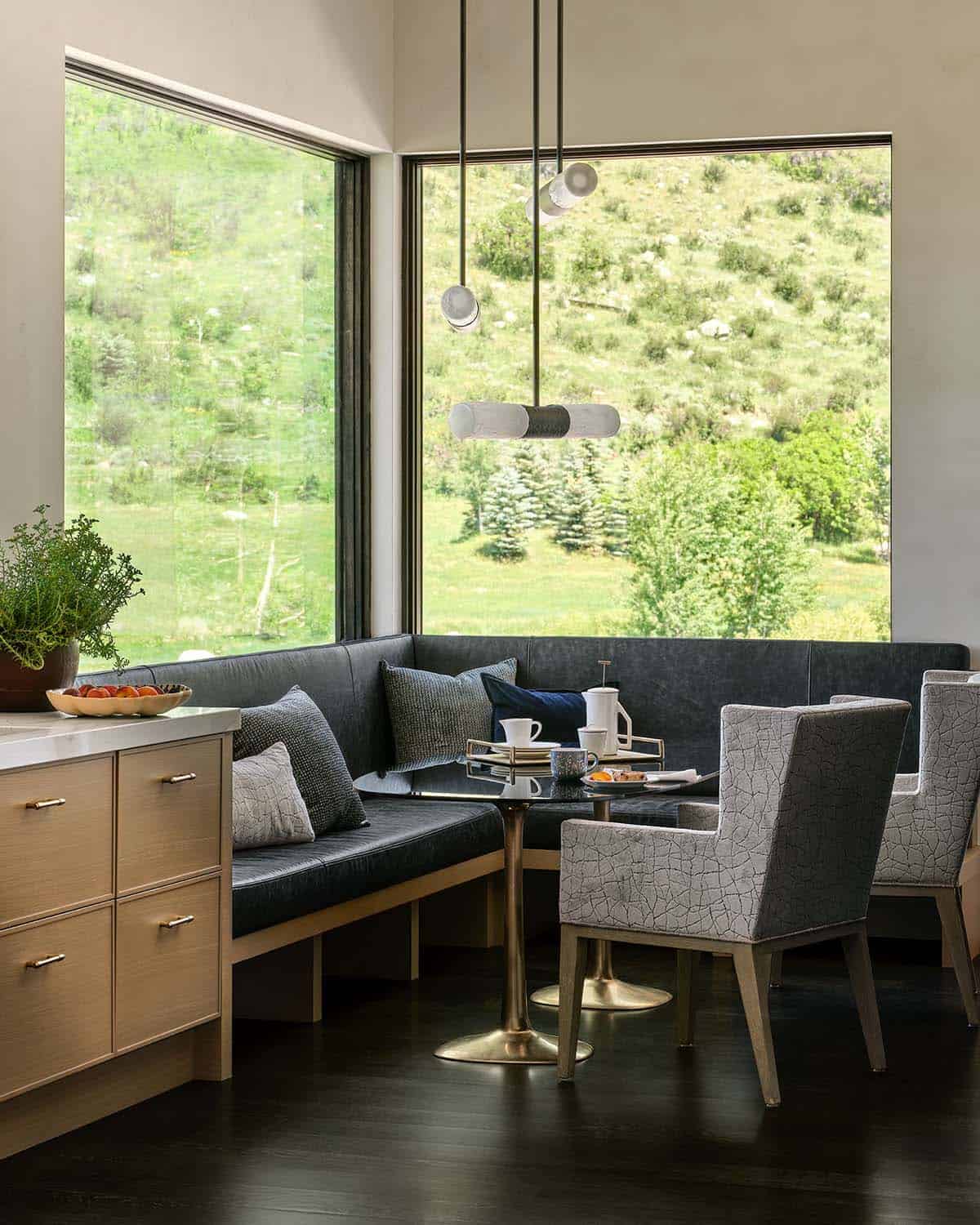 Corner breakfast nook with dark leather banquette and sculptural pendant lights