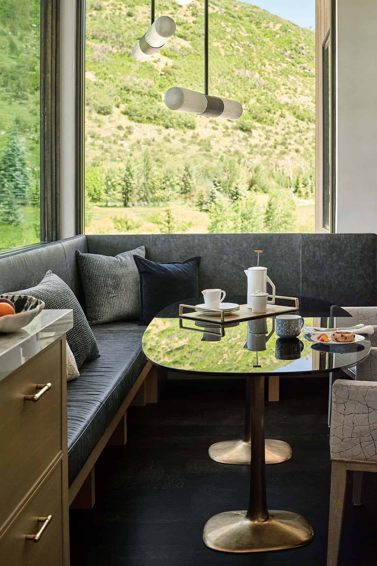 Breakfast nook table set for coffee with mountain view through corner windows