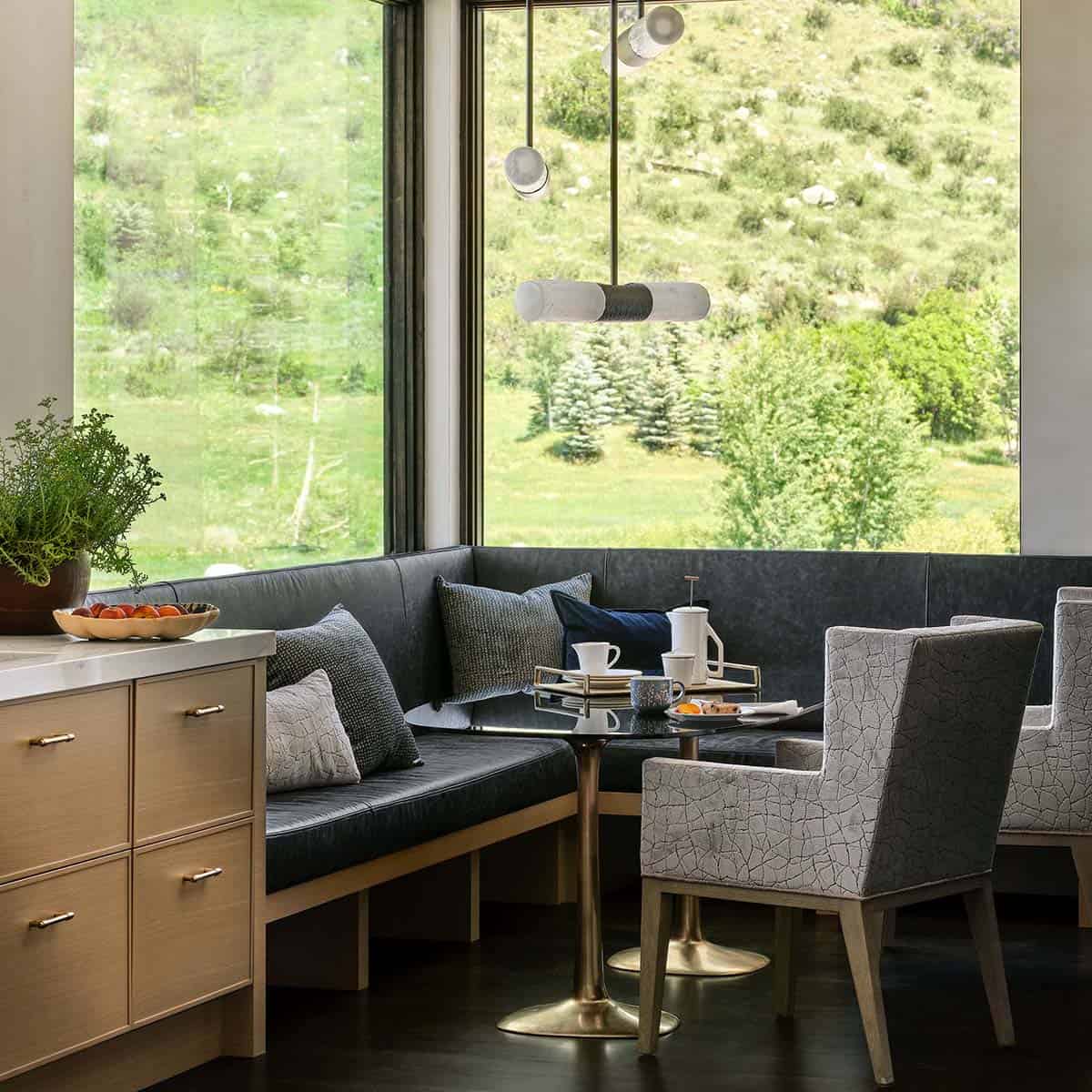 Corner breakfast nook seating with gray leather bench and mountain view