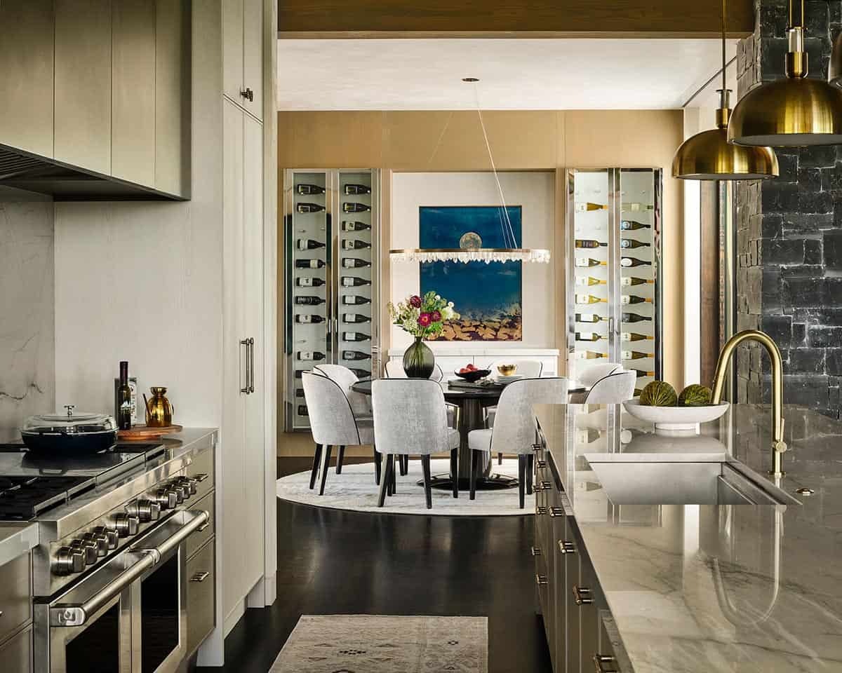 Kitchen counter view toward round dining table with wine storage in background