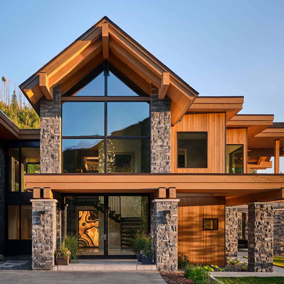 Close-up of home's gabled entrance with floor-to-ceiling windows
