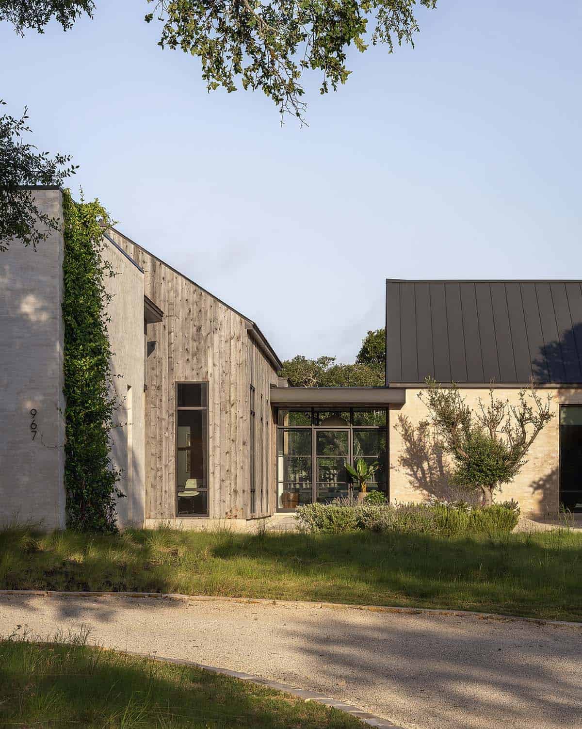 Weathered wood siding meets pale stone at the home's entry courtyard
