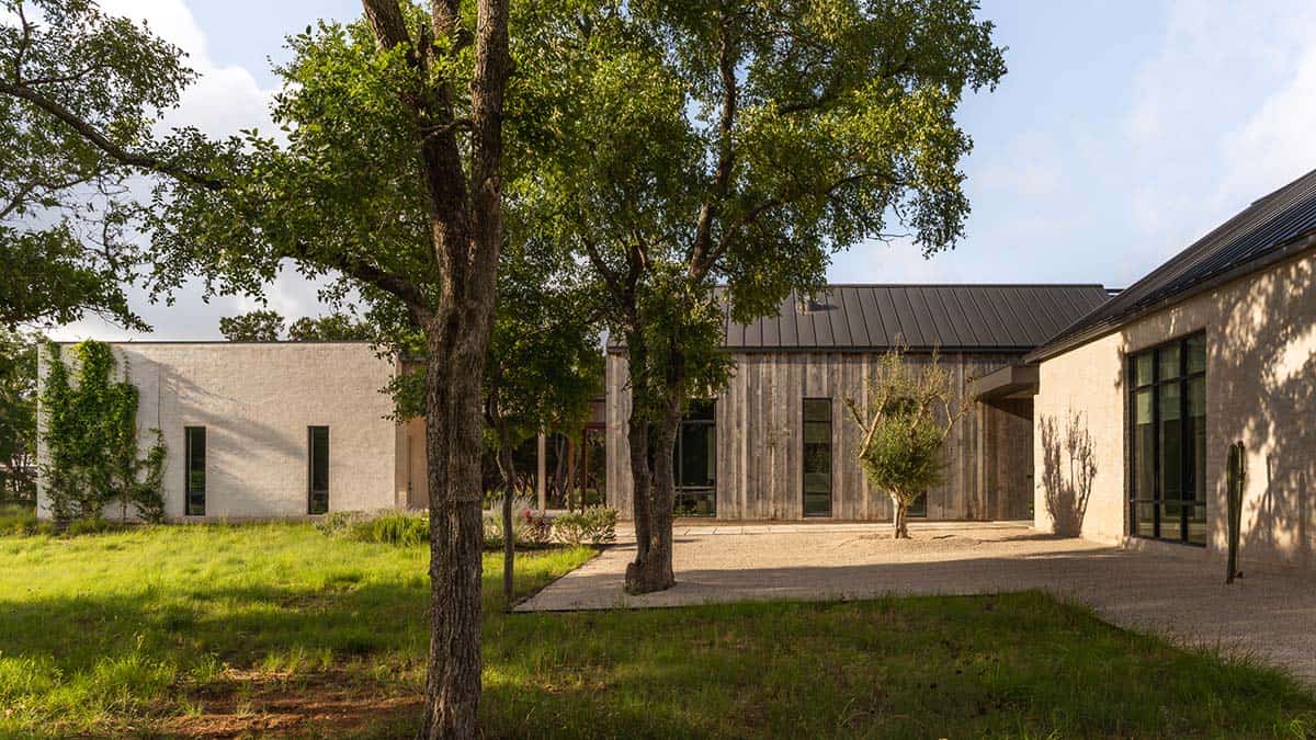 Courtyard oak trees separate the stucco wing from the wood-clad living pavilion
