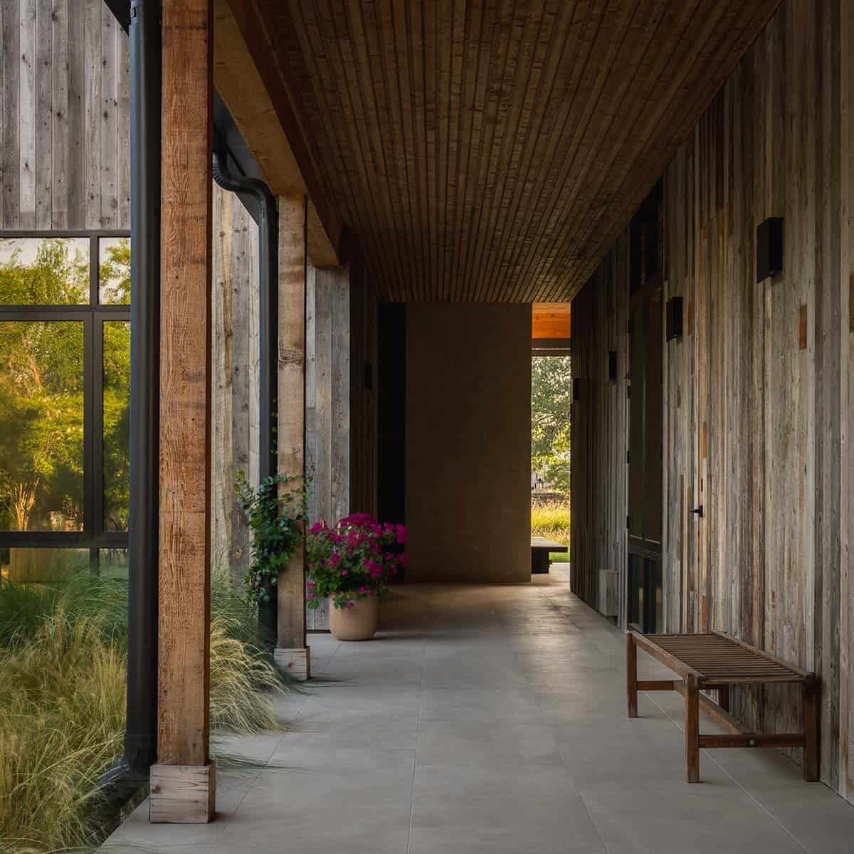 Covered breezeway with wood-slat ceiling leads past a blooming bougainvillea