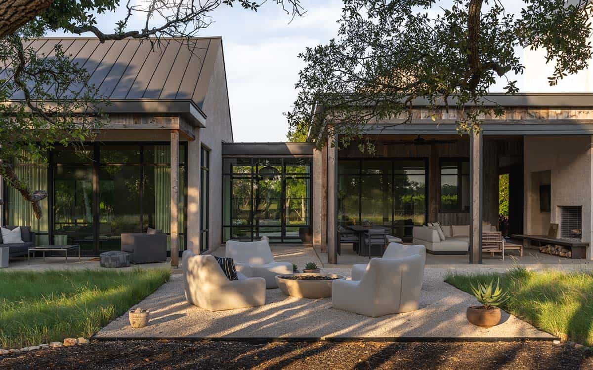 Outdoor fire pit seating area bridges two wings of the home