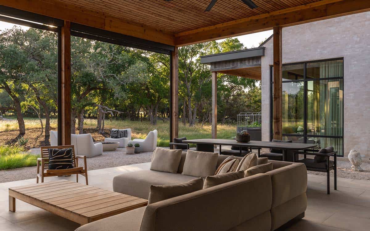 Covered outdoor living room opens to the pasture beyond the pergola 