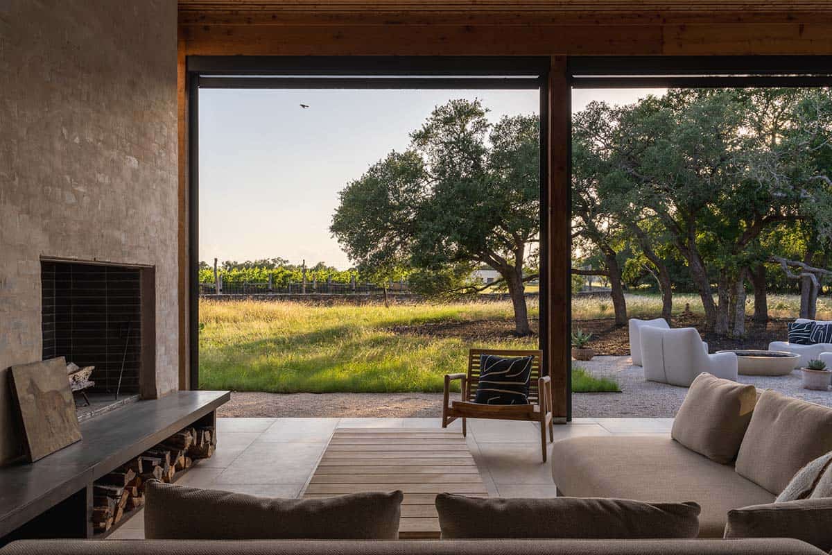 Living room sofa faces sliding glass doors framing an oak-studded pasture
