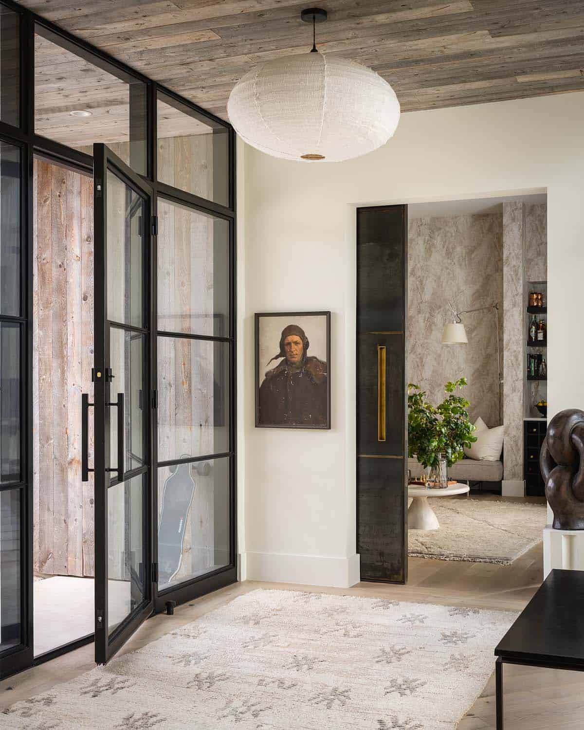 Entry foyer with woven pendant light and a vintage portrait painting