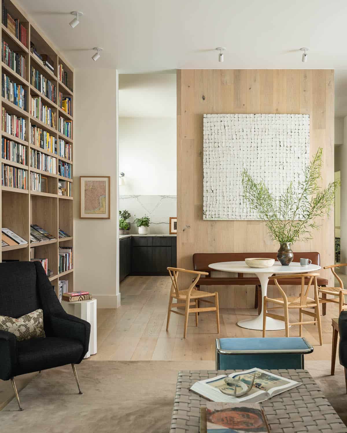 Open living and dining area anchored by a floor-to-ceiling bookcase