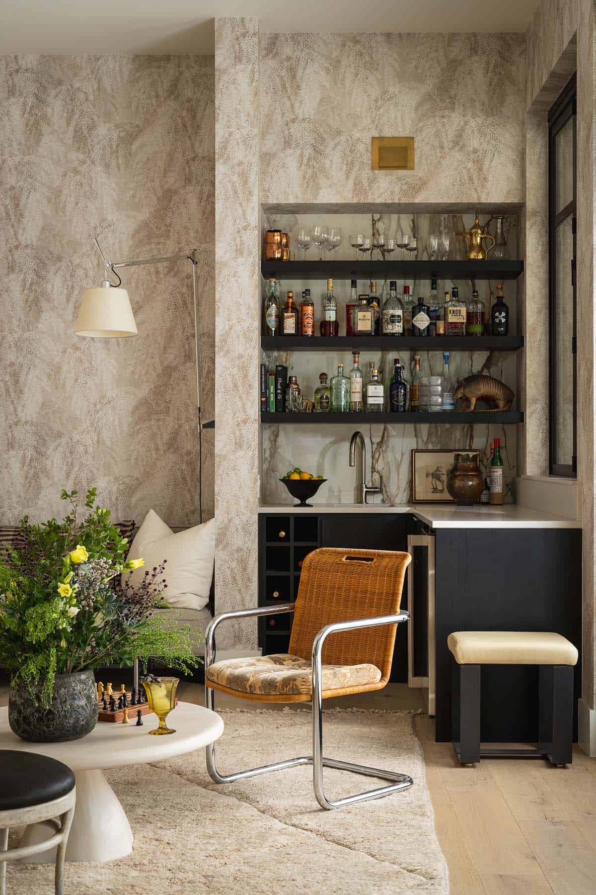 Bar nook with black shelving stocked with glassware and bottles