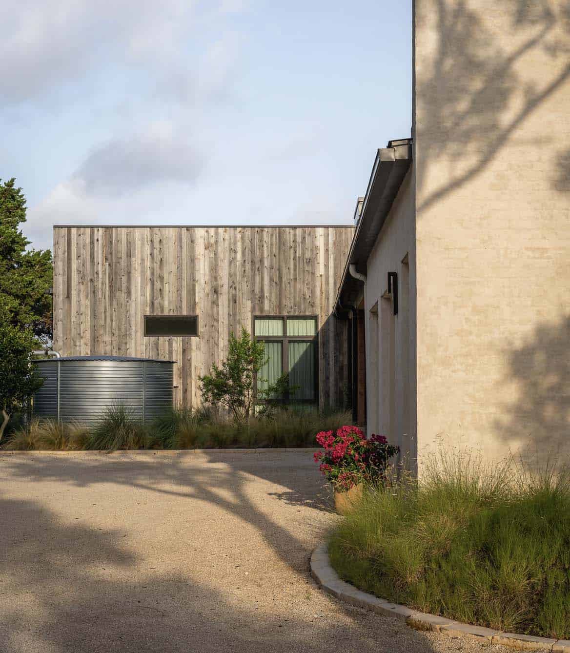 Wood-clad addition with water tank sits beside the home's stucco wing