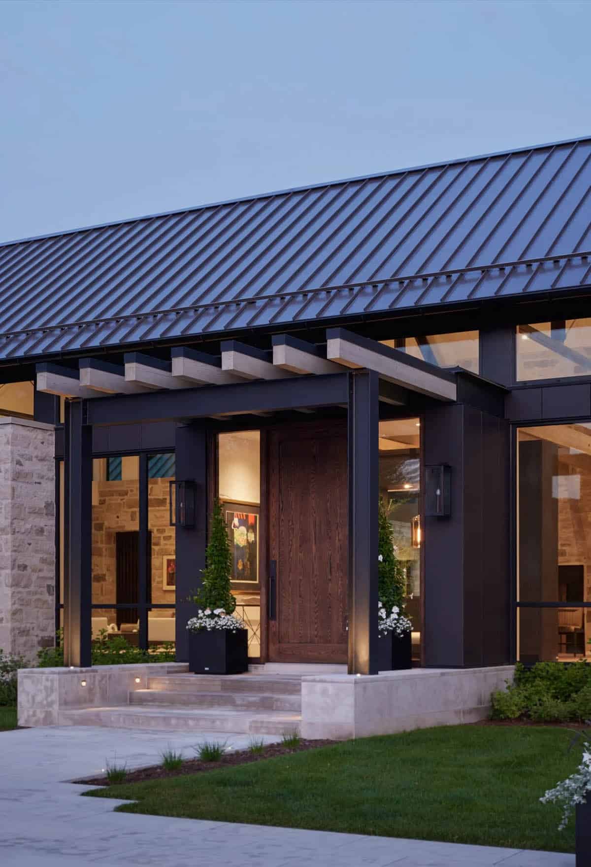 Entryway with wood front door, black steel pergola, and stone wall facade