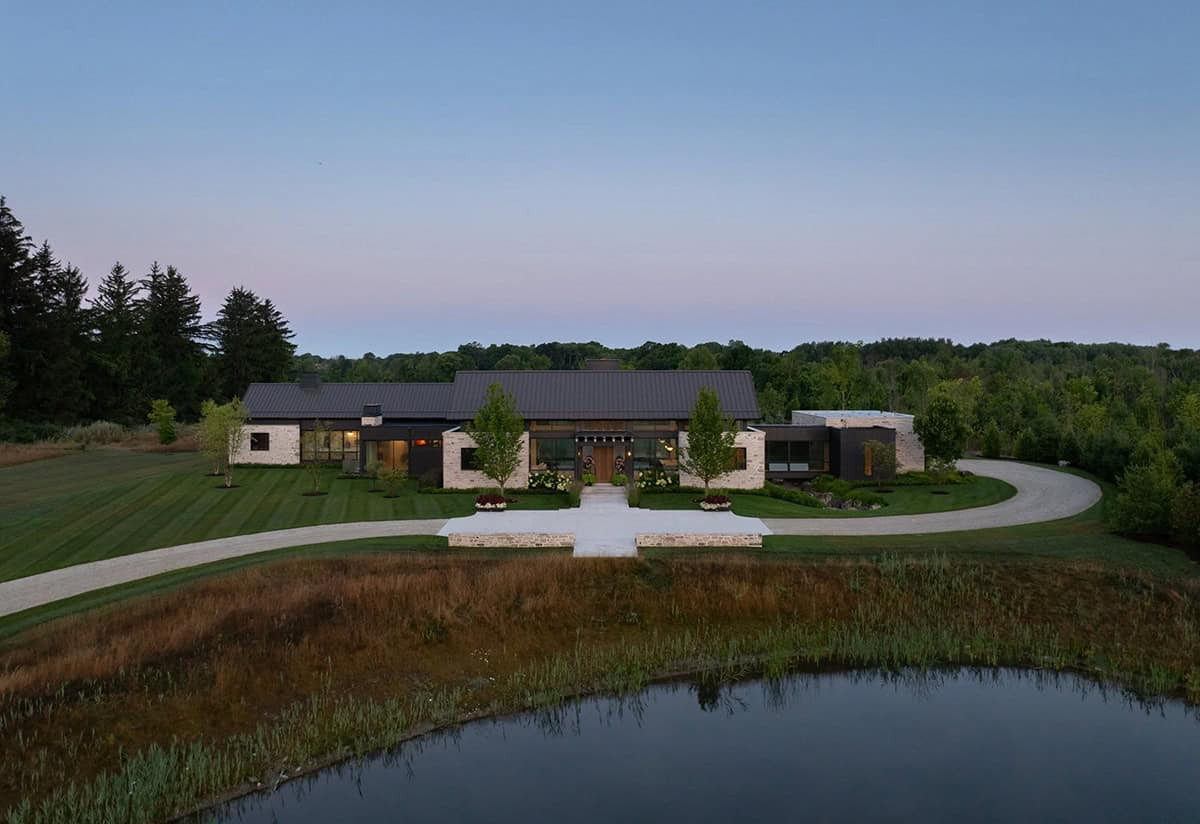 Aerial view of home's three pavilions with pond in foreground