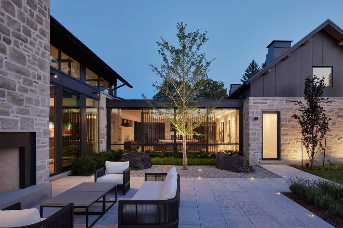 Interior courtyard patio with outdoor seating, stone walls, and glass-enclosed breezeway