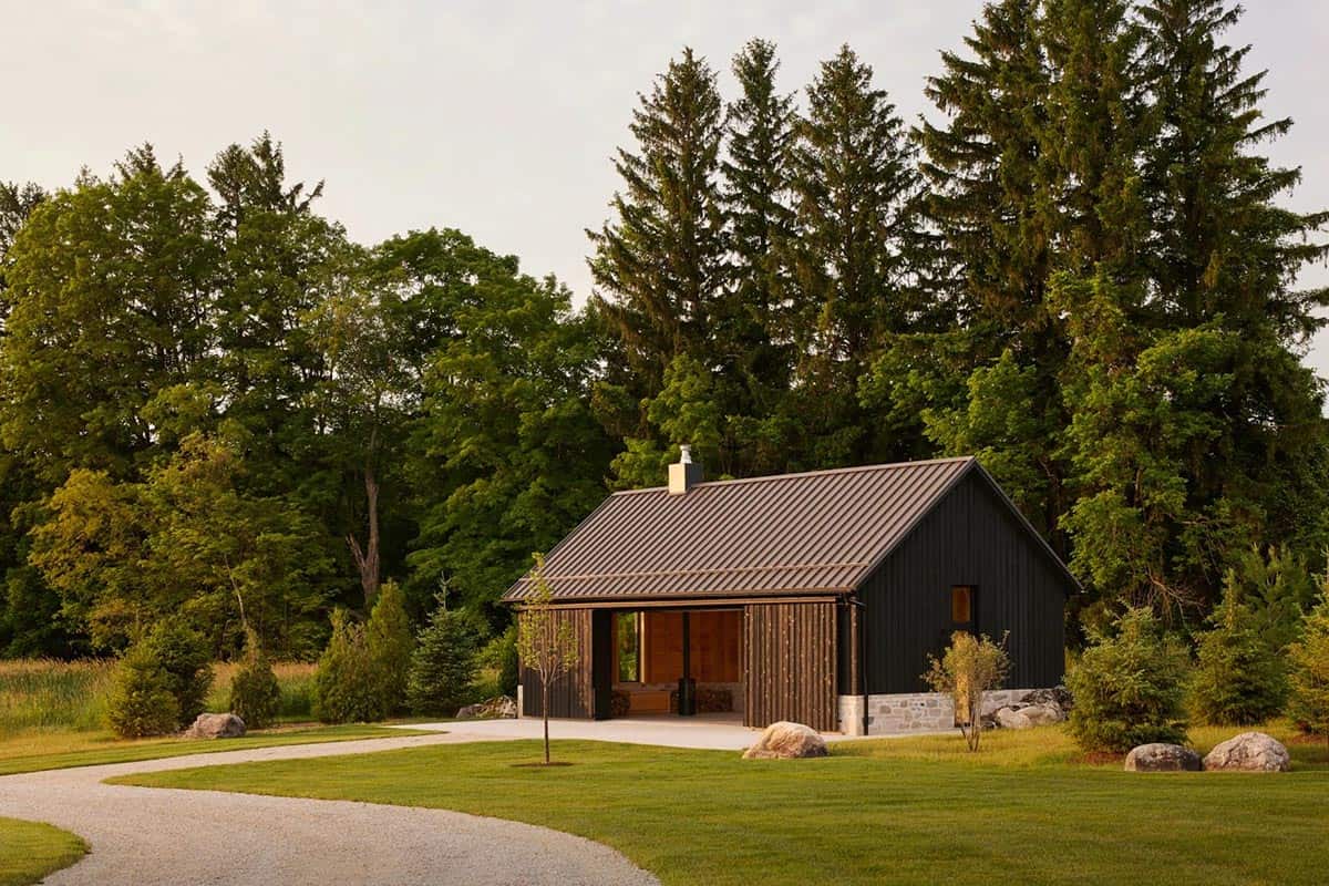 Gathering pavilion with wood siding nestled among pine trees