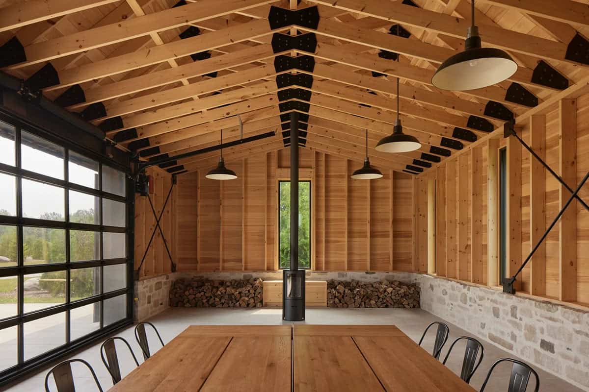 Vaulted wood-paneled interior of gathering pavilion with exposed trusses and long dining table