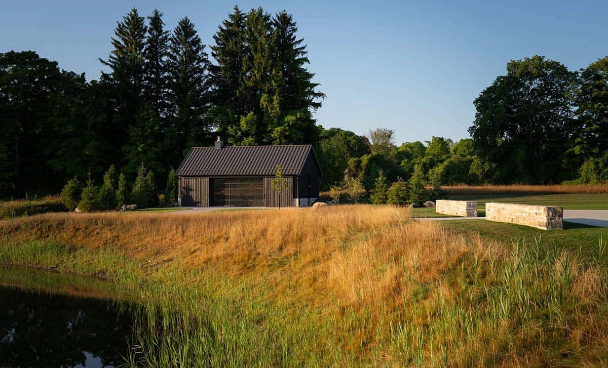 Garage pavilion and low stone garden walls beside pond at golden hour