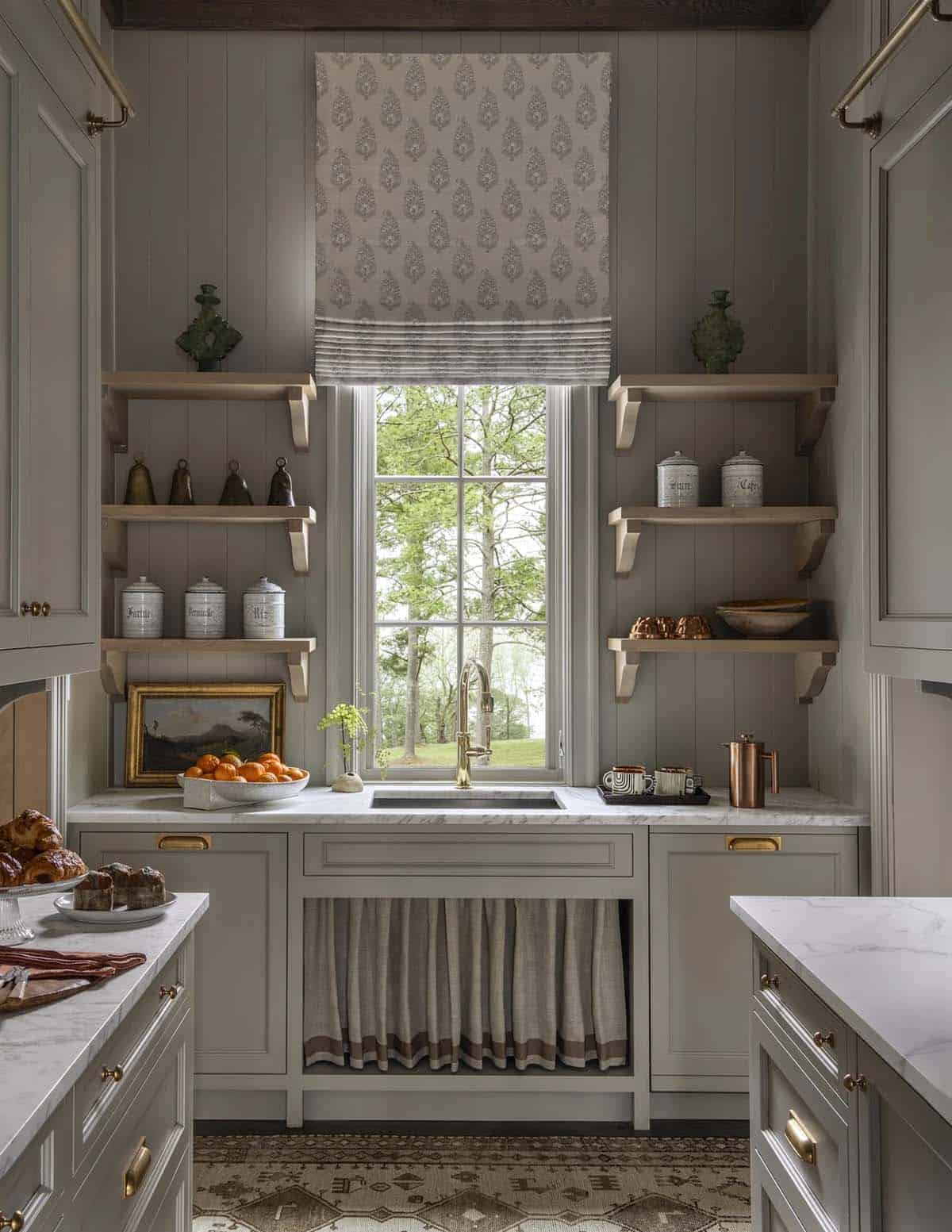 Butler's pantry with taupe cabinetry, open shelving, and a curtained window over the sink