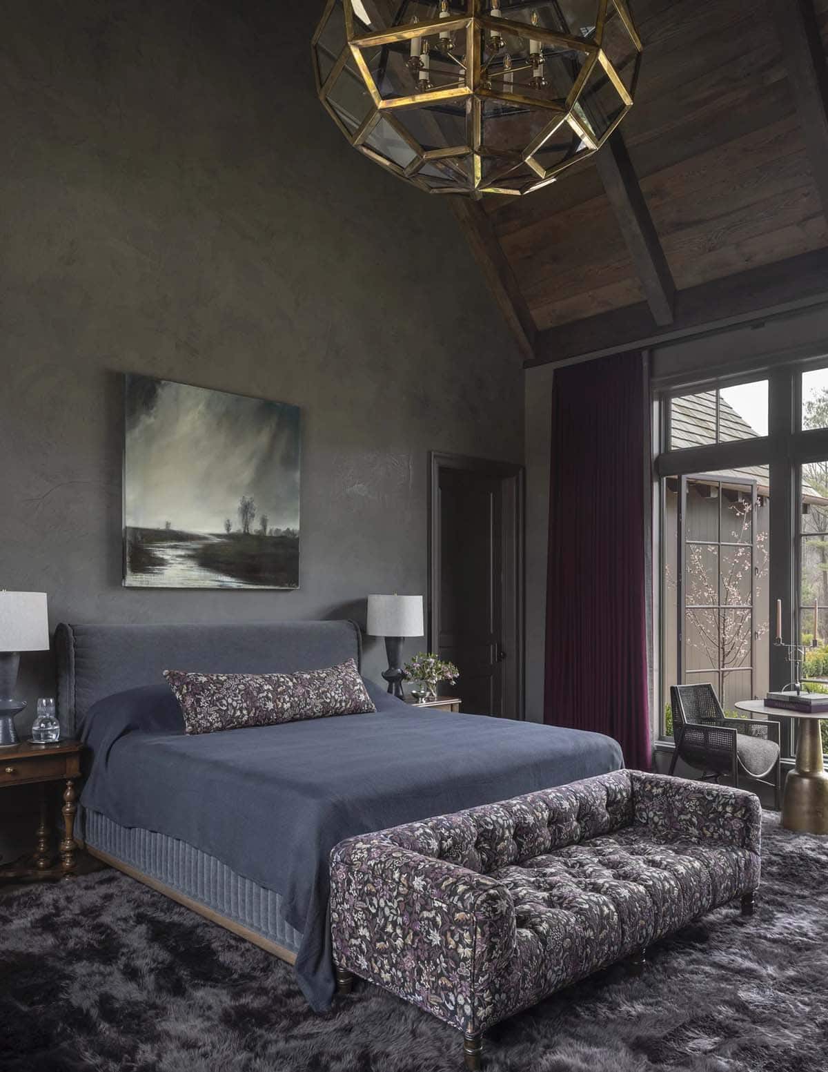 Moody bedroom with vaulted wood ceiling, geometric brass chandelier, and burgundy drapes