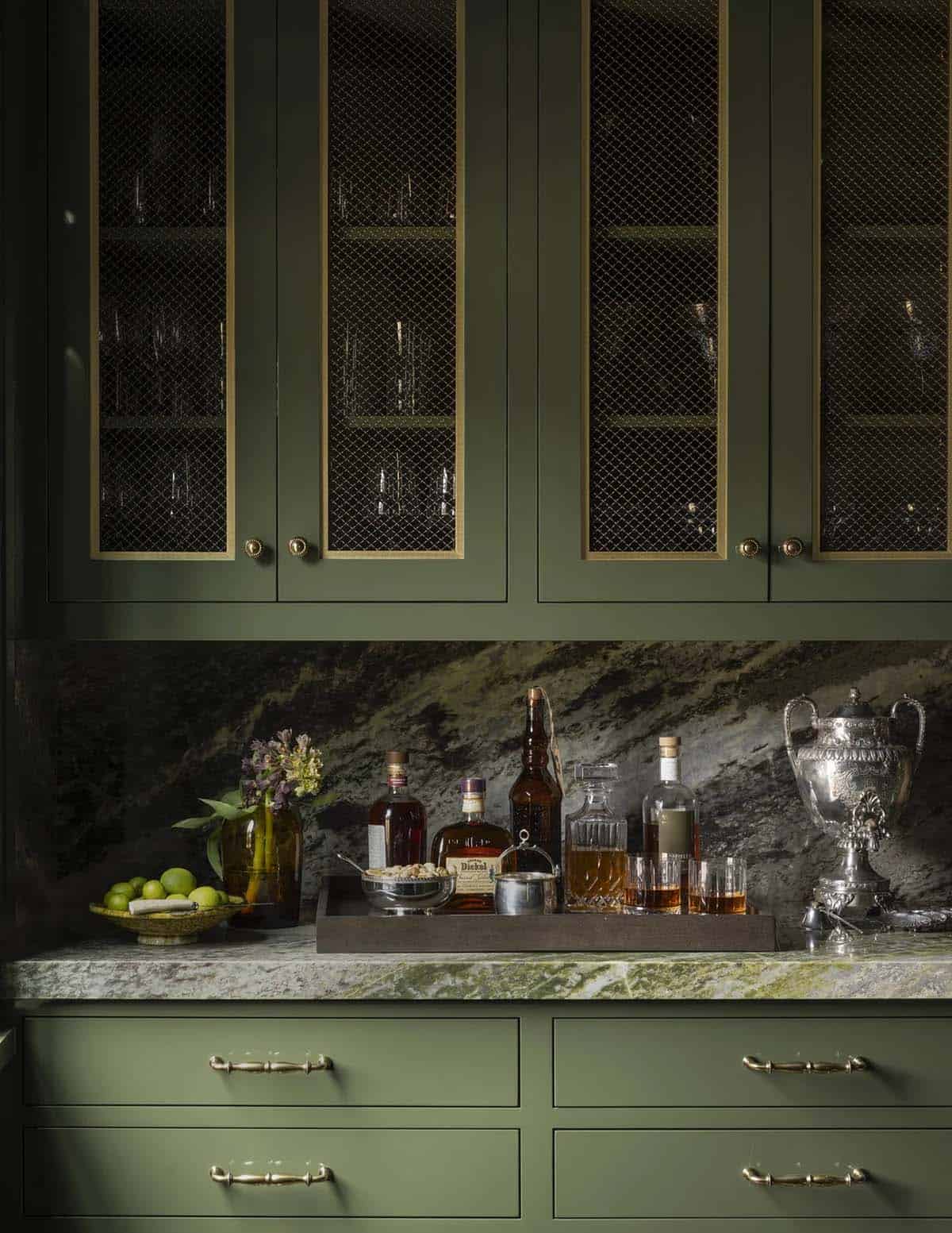 Wet bar detail with green cabinetry, mesh-front doors, and a stone backsplash