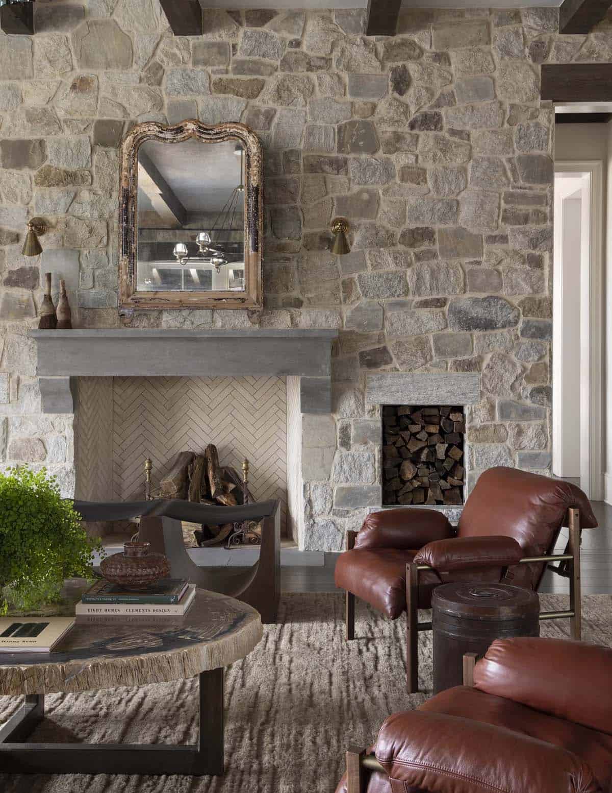 Stone fireplace wall with vintage mirror, leather chairs, and a live-edge coffee table