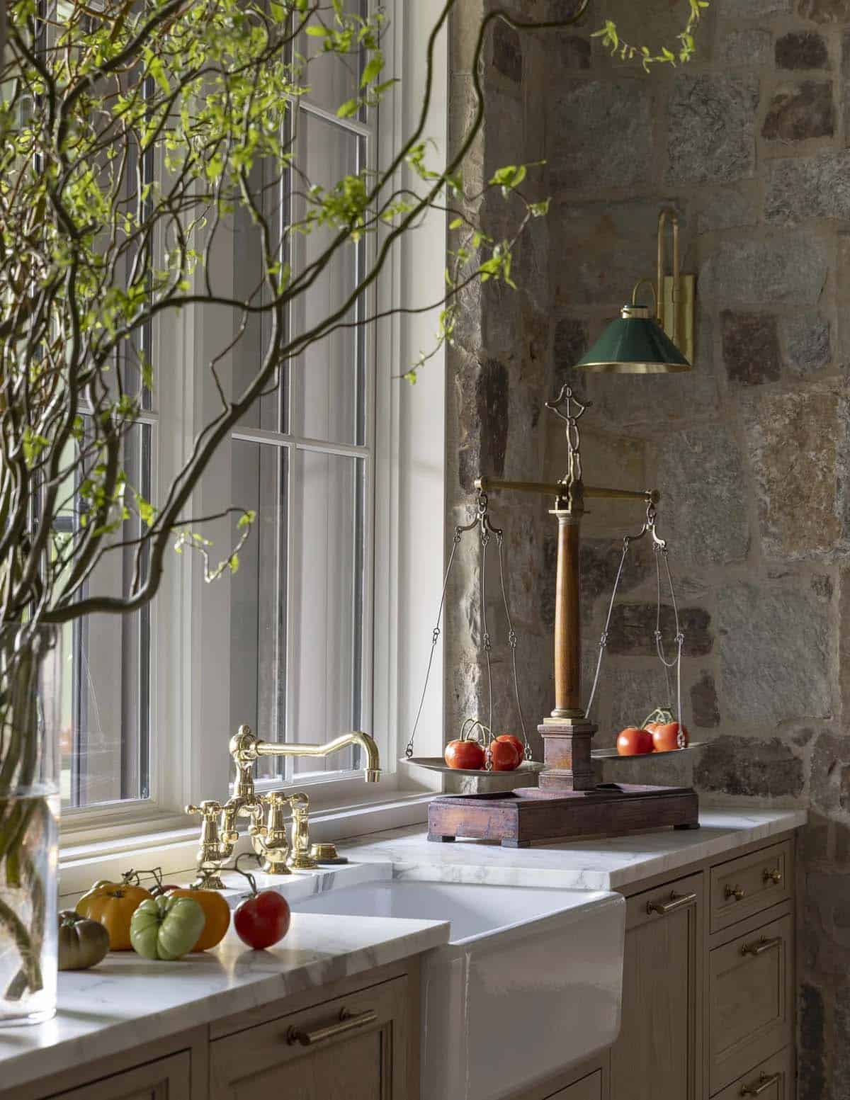 Kitchen sink area with brass gooseneck faucet, antique scale, and heirloom tomatoes
