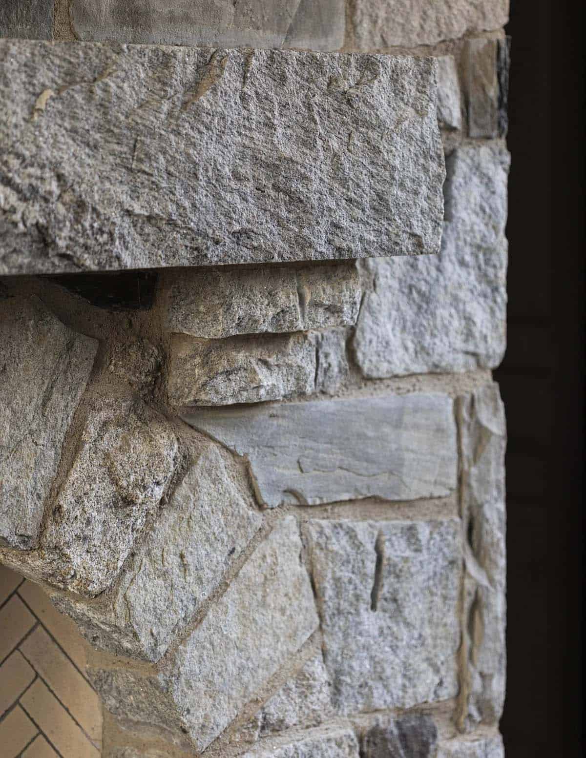Close-up detail of rough-cut stacked stone fireplace corner