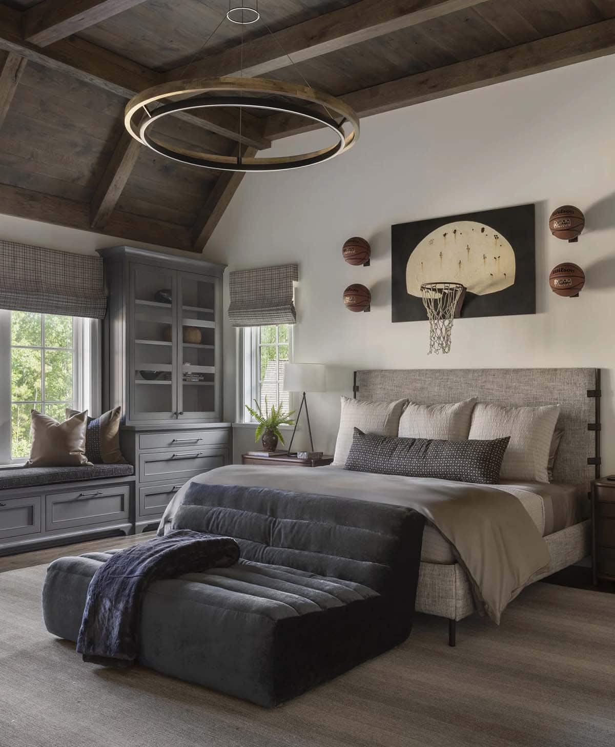 Boy's bedroom with gray upholstered bed, basketball-hoop art, and round LED chandelier
