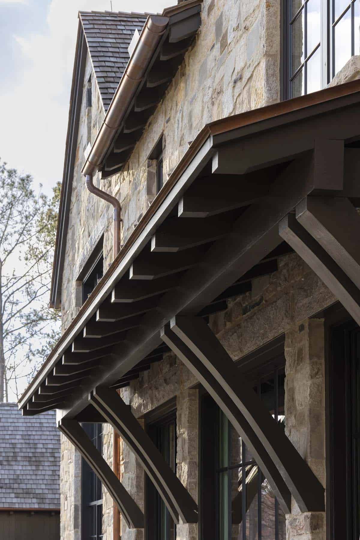 Detail of stone gable, copper gutter, and exposed rafter tails on the exterior