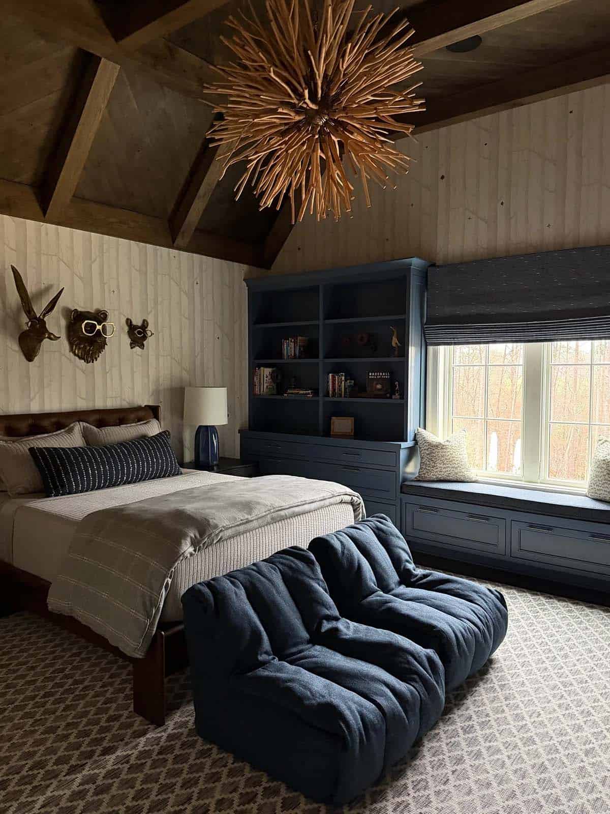 Kid's bedroom with starburst wood chandelier, navy built-ins, and animal wall hooks