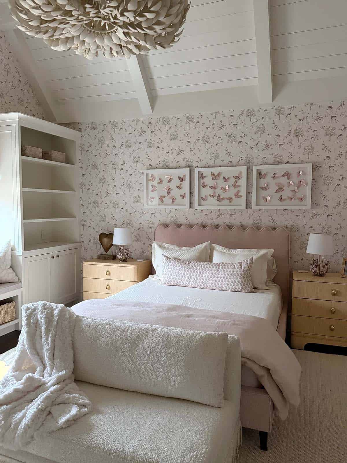 Girl's bedroom with scalloped pink headboard and feathered flower chandelier
