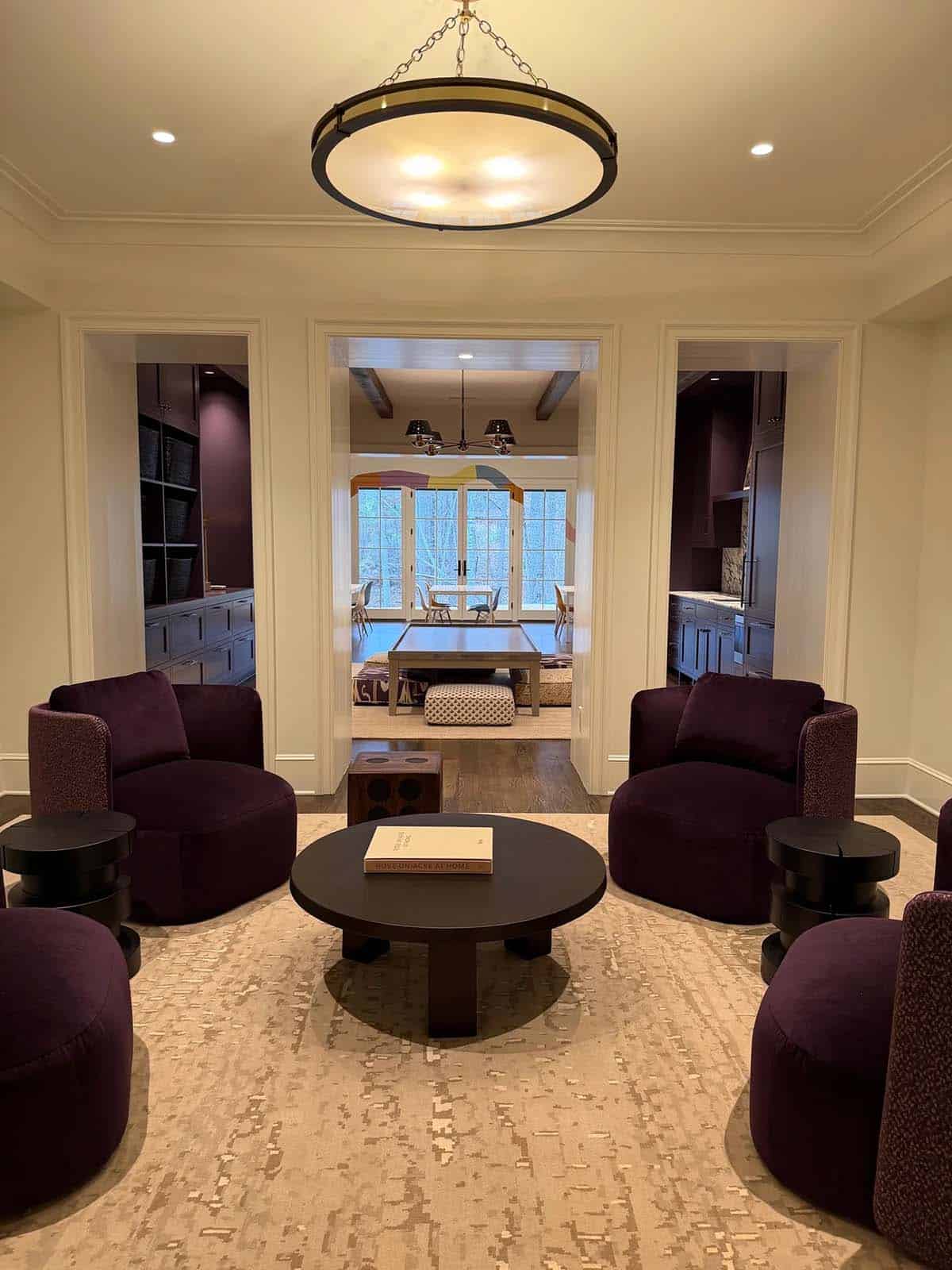 Plum velvet lounge with round black coffee table opening onto the billiard and craft rooms