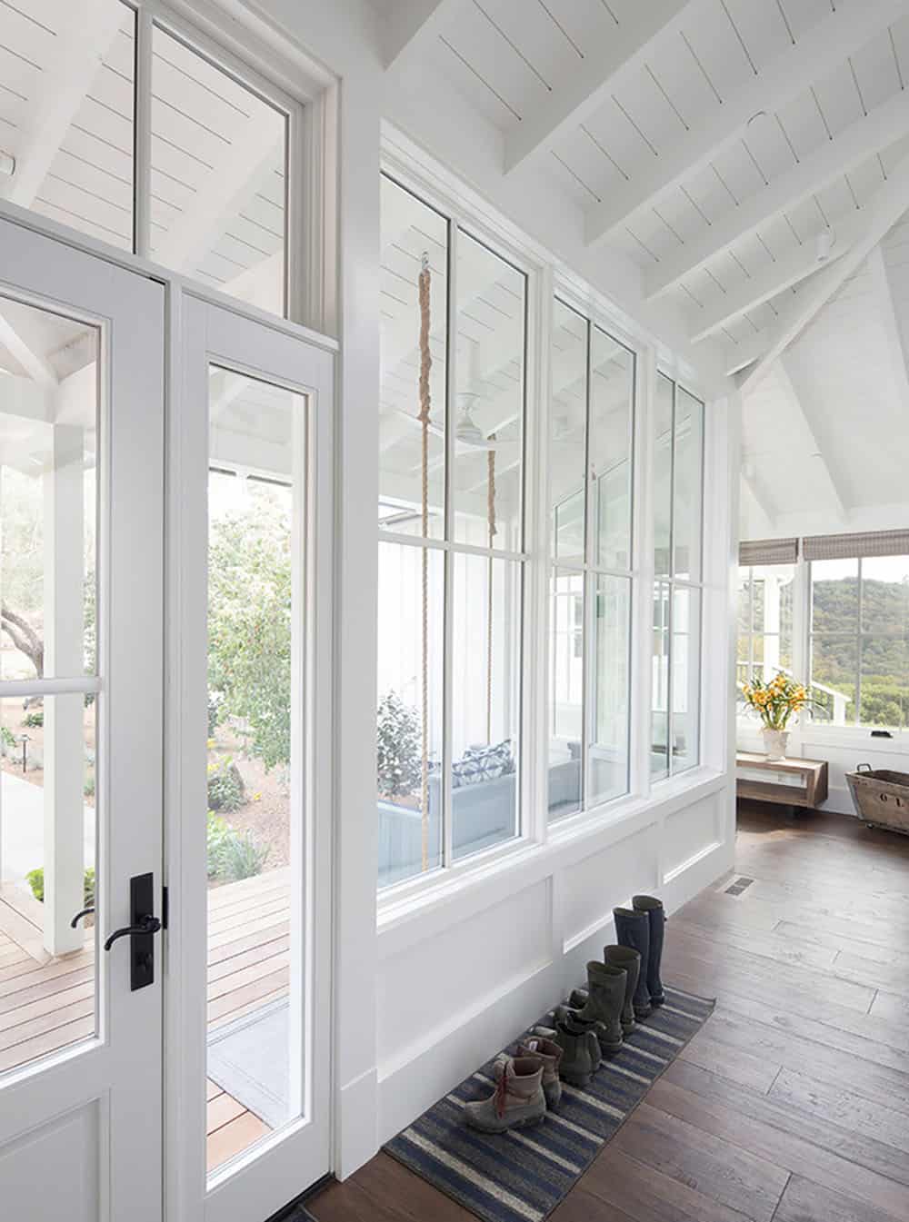Bright entry hallway with screened porch views, vaulted ceiling, and boot mat