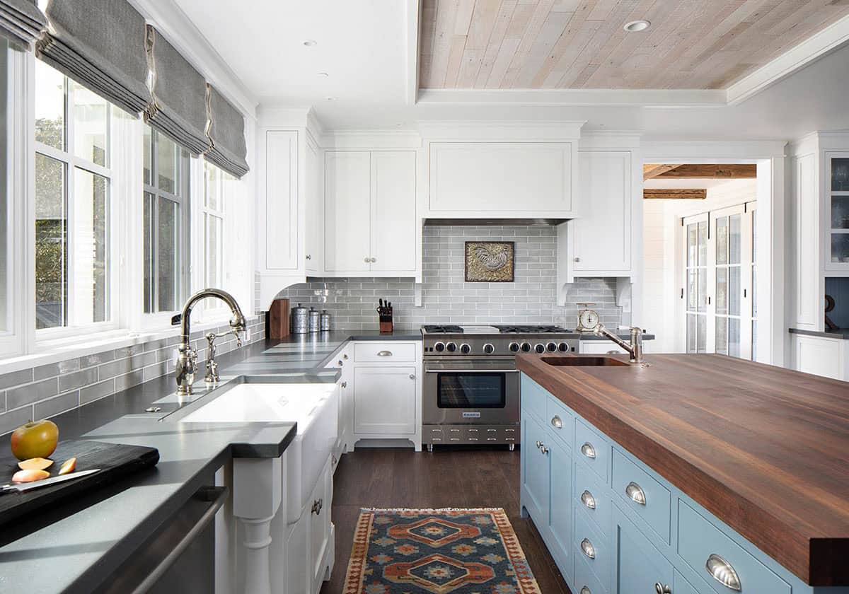Kitchen counter view with gray subway tile backsplash, stove, and Southwestern-style rug