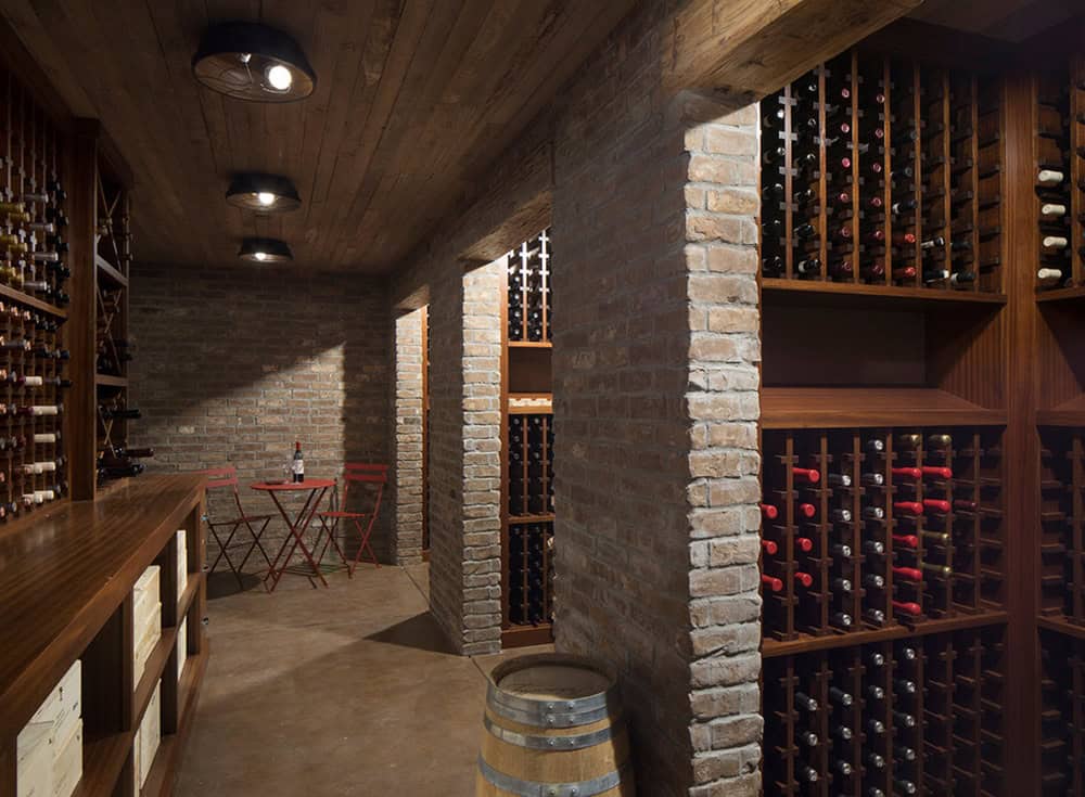 Wine cellar with brick archways, wood racks, and a bistro table