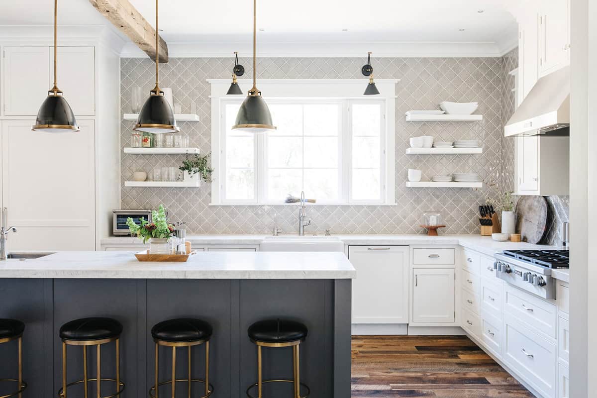 Kitchen with black pendant lights, open shelving, and arabesque tile backsplash
