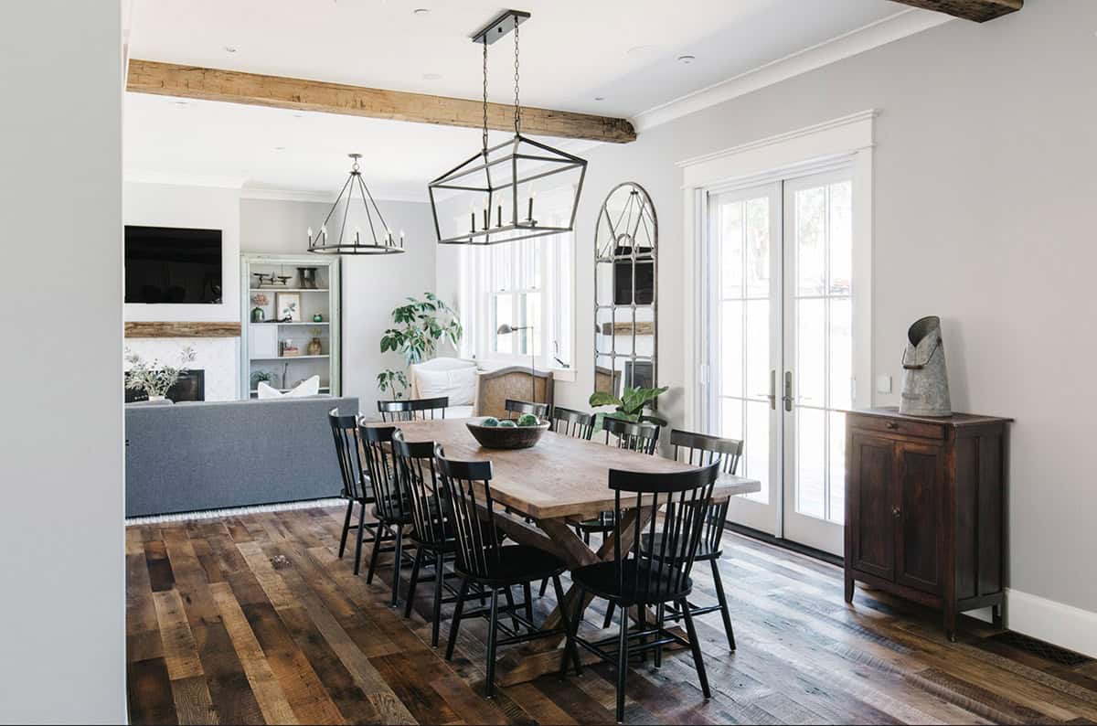 Dining room with lantern-style chandeliers and view into the living area