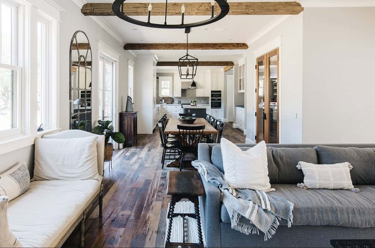 Open-concept living and dining space with exposed wood ceiling beams