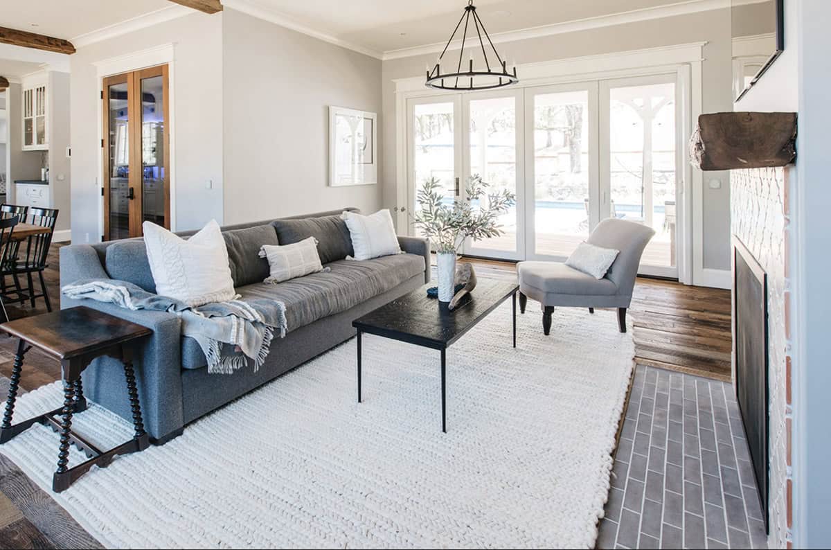 Living room with gray sofa, white rug, and French doors leading to the pool