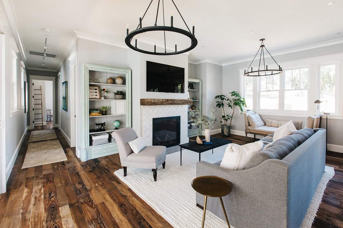 Living room with fireplace, built-in shelving, and round black chandelier