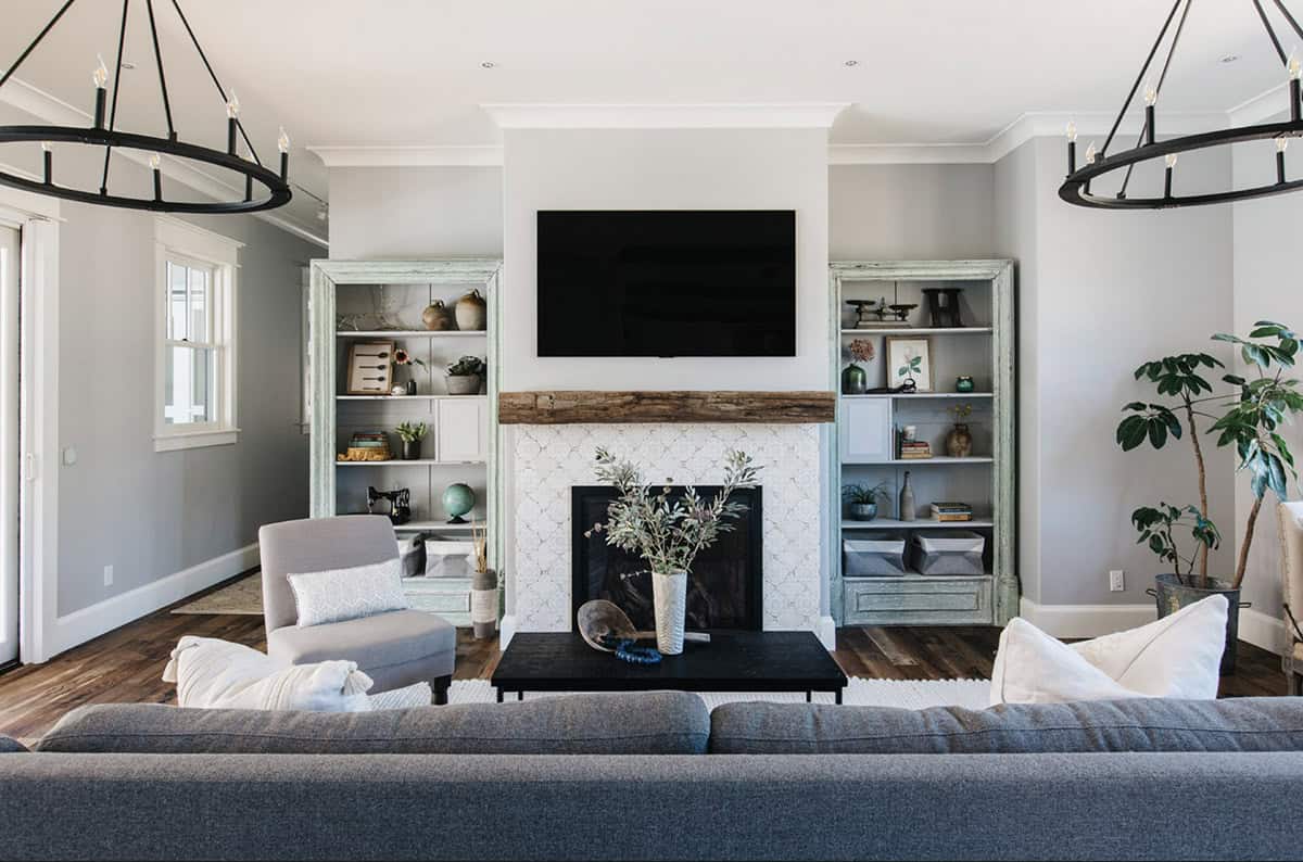 Fireplace with tiled surround flanked by weathered green bookshelves
