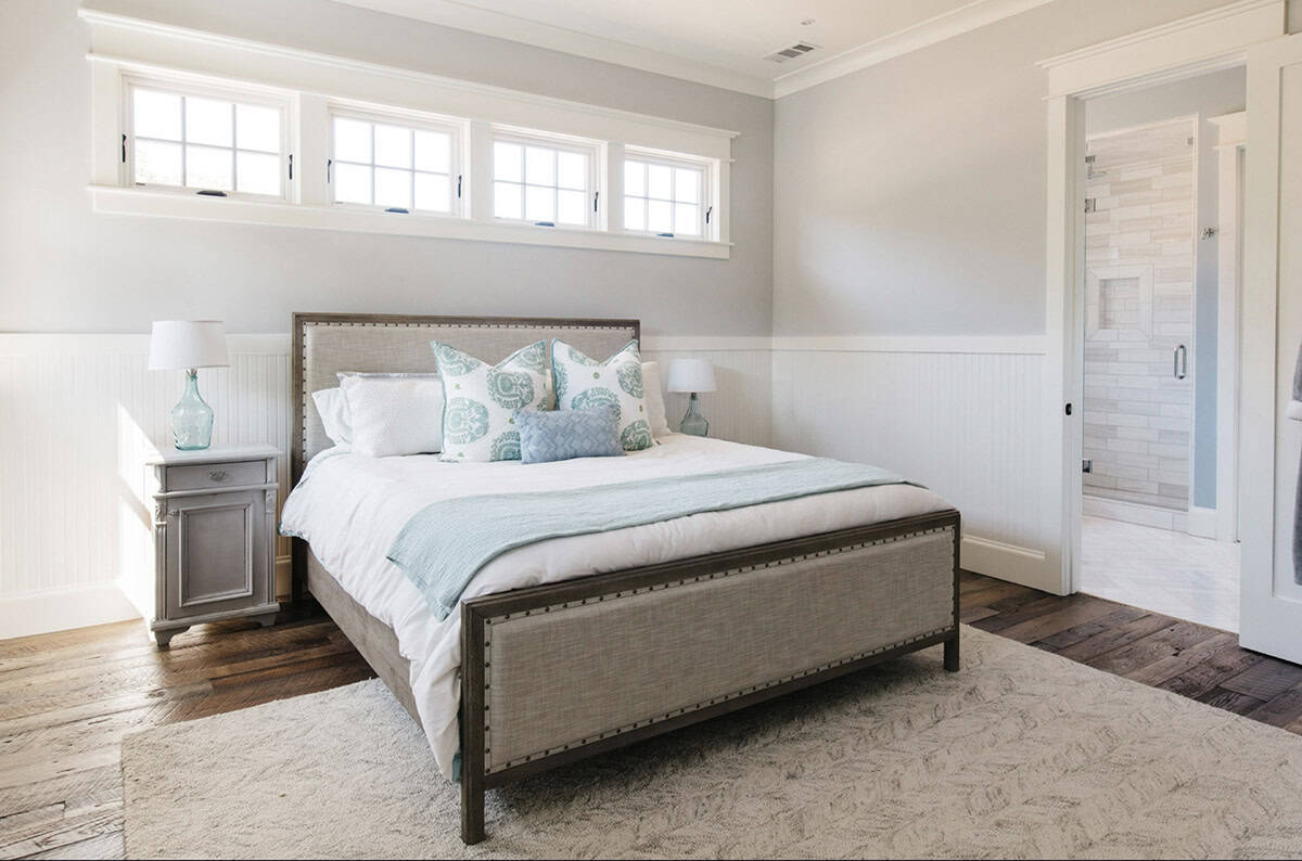 Bedroom with upholstered bed, nightstands, and glimpse into an en-suite bathroom