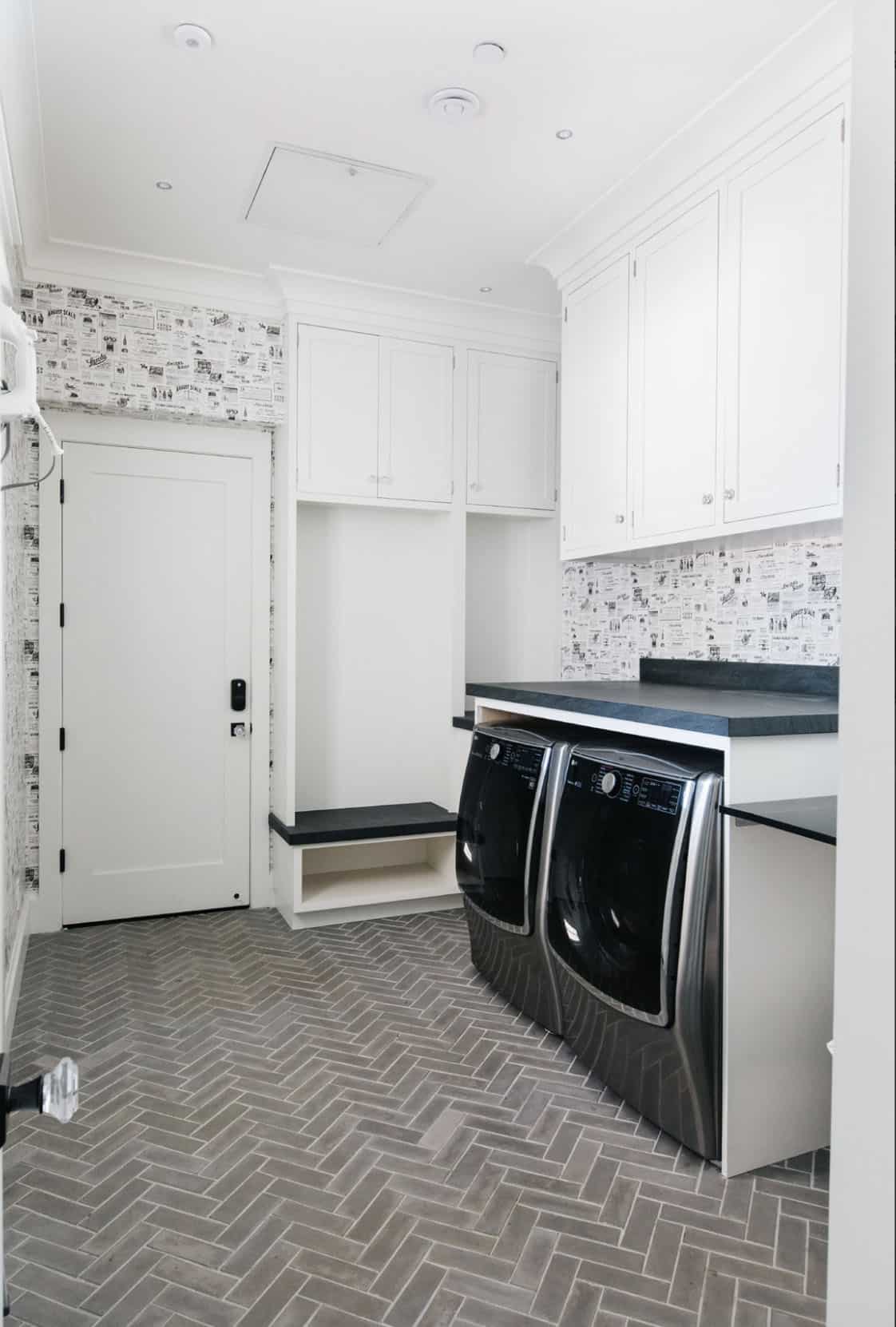 Mudroom and laundry room with herringbone tile floor and vintage newsprint wallpaper
