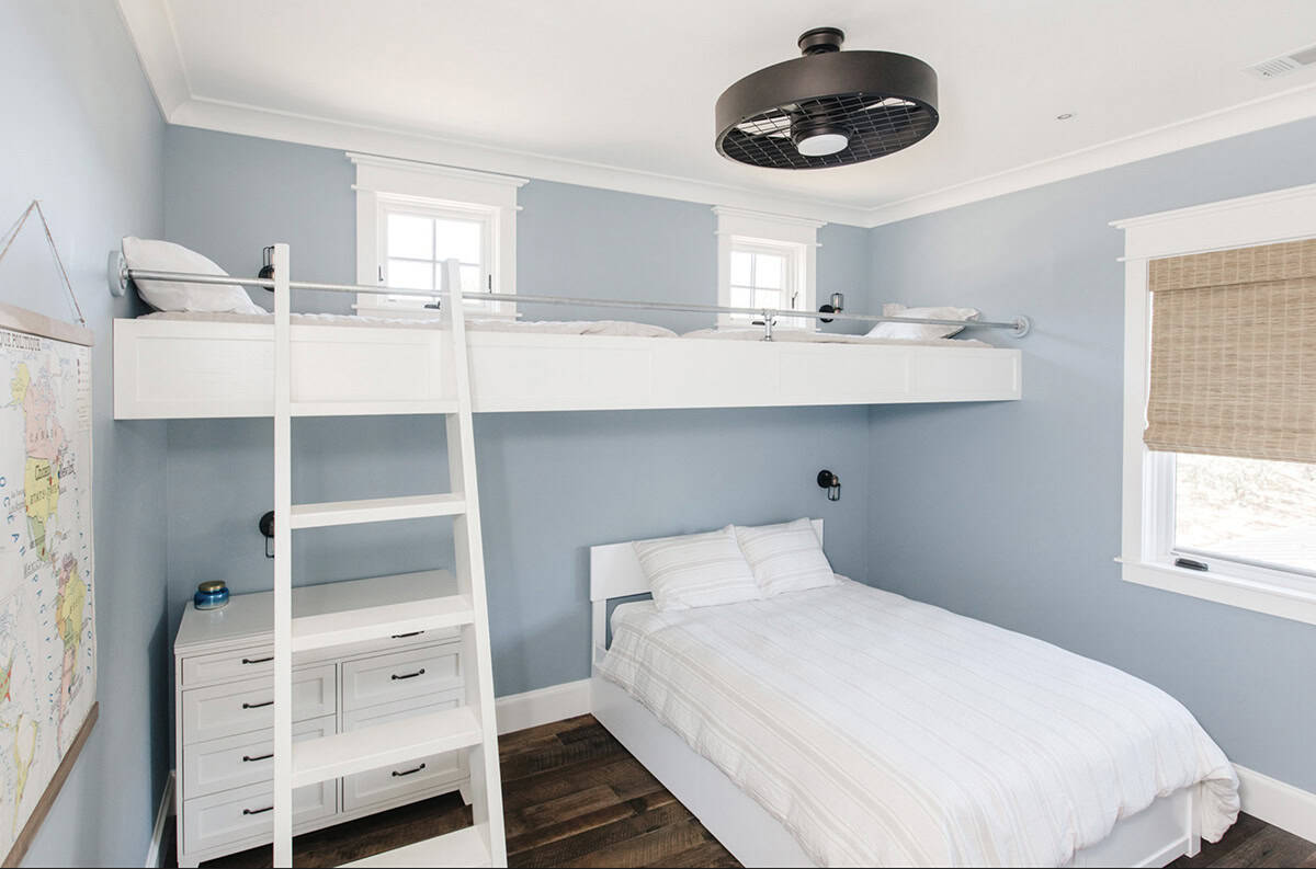 Kids' bedroom with elevated loft bed, ladder, and blue walls