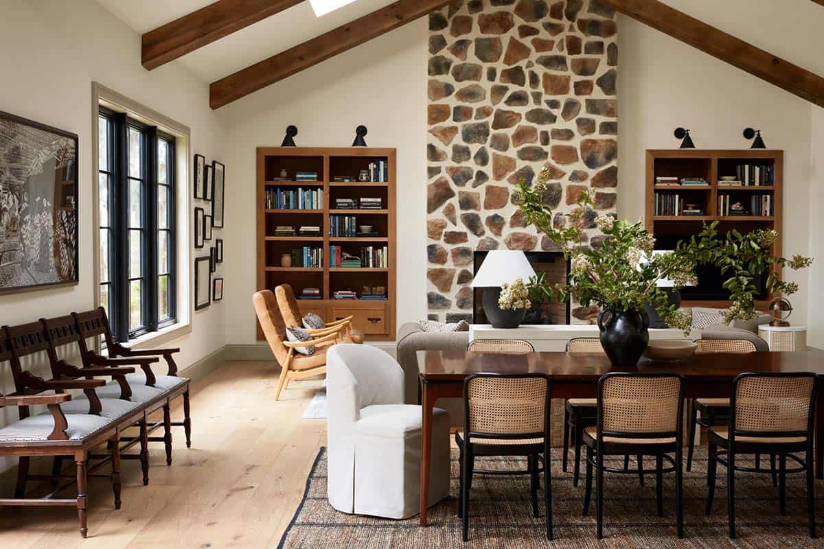 Vaulted living room with stone fireplace and rustic wood ceiling beams