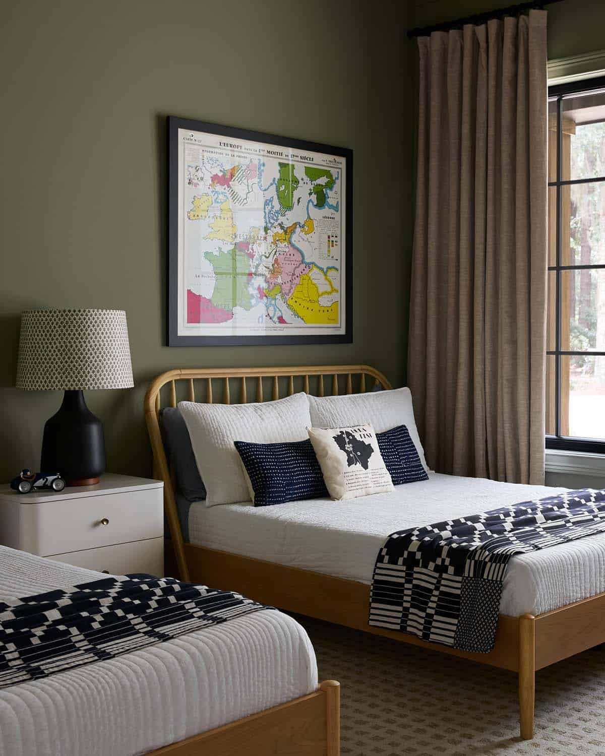 Bunk room with olive green walls and vintage map art