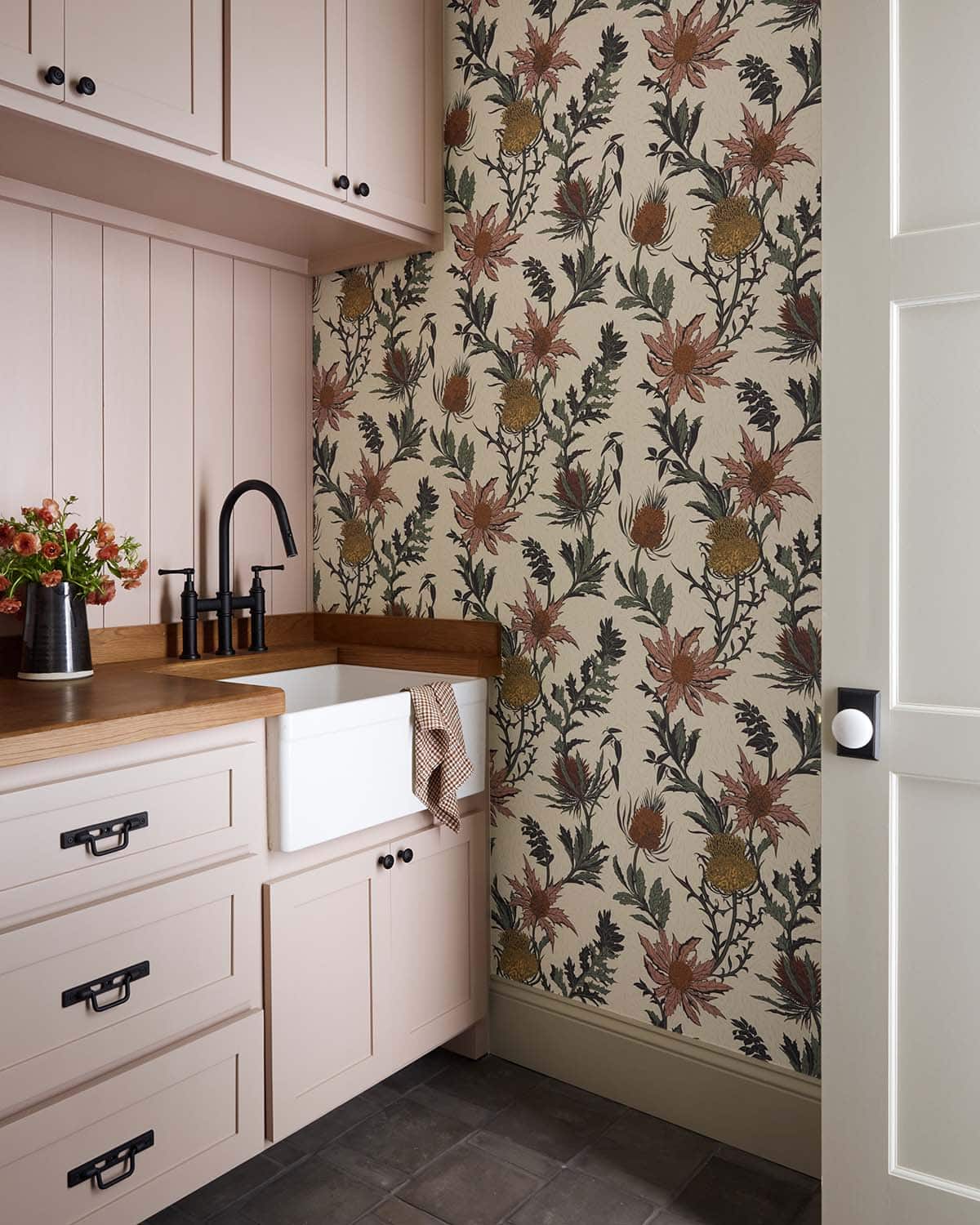 Blush laundry room with farmhouse sink and thistle wallpaper
