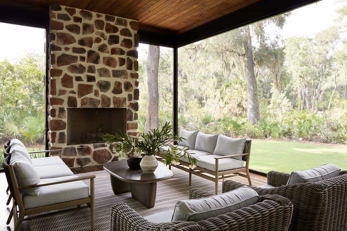 Screened porch with stone fireplace and wicker outdoor seating