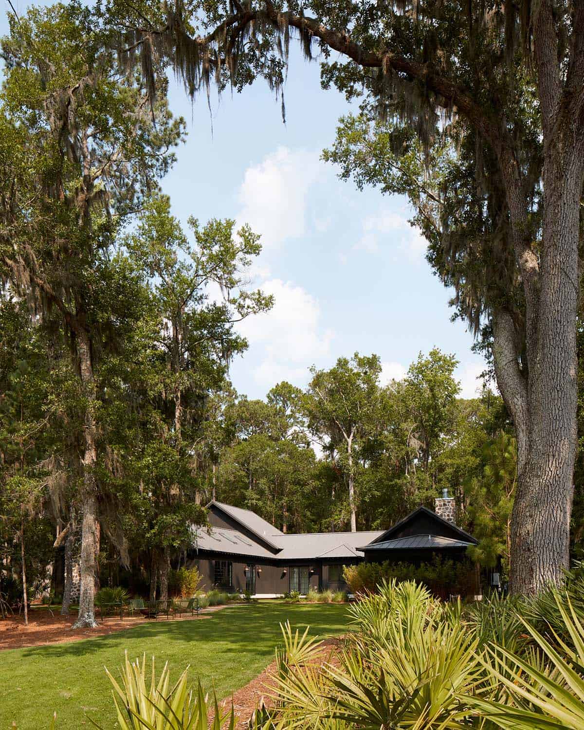 House framed by oak canopy with hanging spanish moss