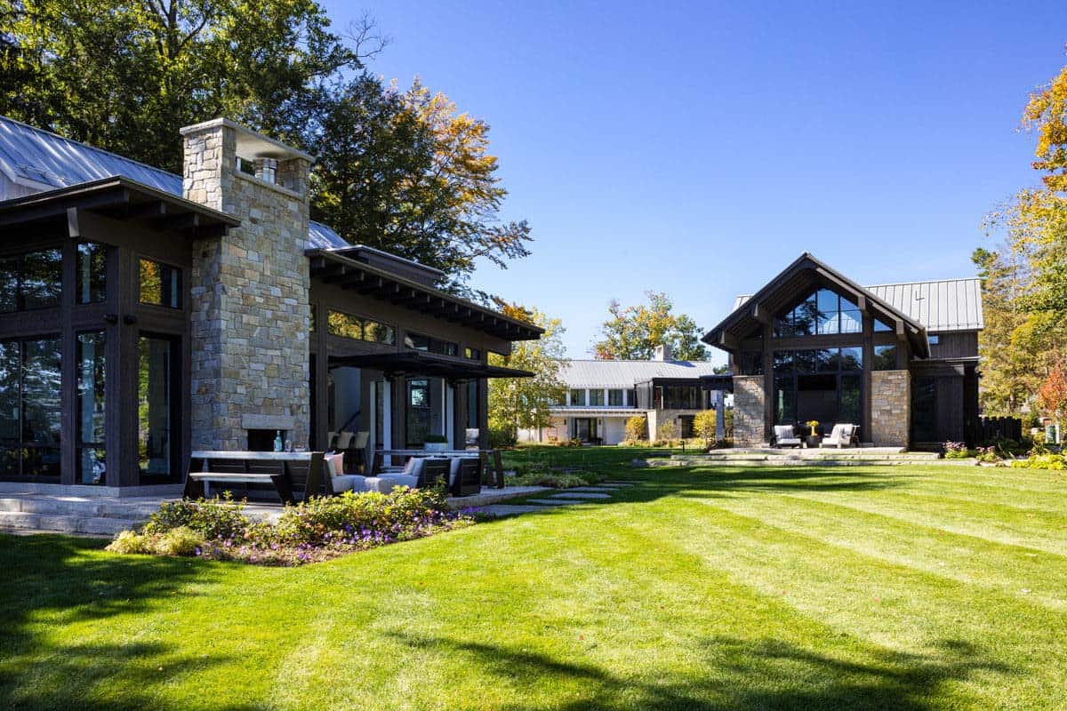 Exterior view of stone chimney, glass walls, and outdoor lounge area